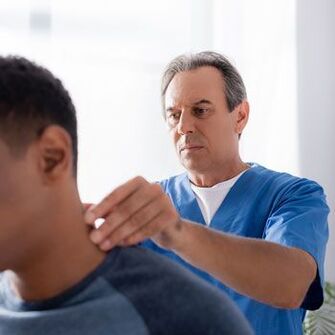Un medic efectuează un examen de diagnostic pe un pacient cu dureri de gât.